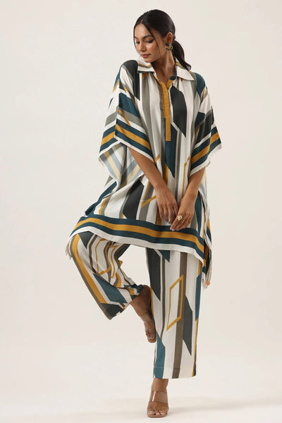 Fashion forward abstract stripe coordination set, featuring a flowing top and wide leg pants in a striking pattern of teal, black, and gold.