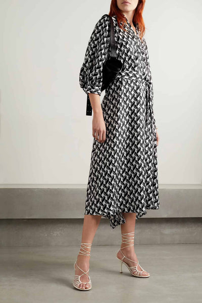 Black-and-white geometric-print midi wrap dress with tie waist and three-quarter sleeves.