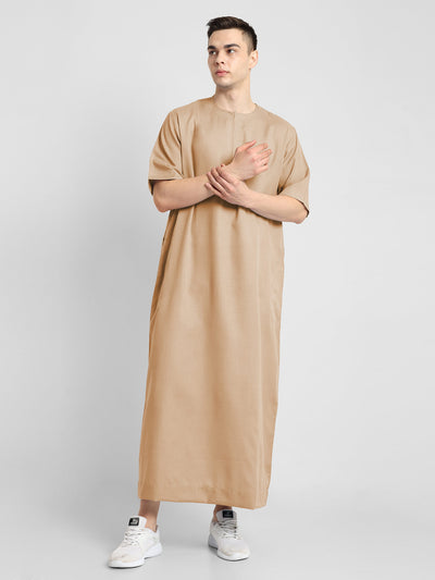 Man wearing a Beige, ankle-length thobe with a relaxed fit, embodying a fusion of traditional charm and modern simplicity