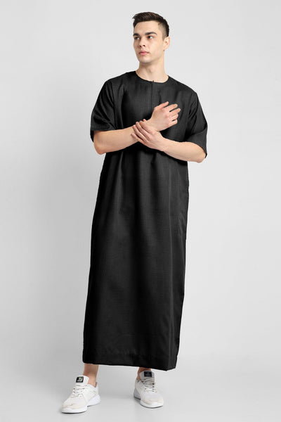 Man wearing a black, ankle-length thobe with a relaxed fit, embodying a fusion of traditional charm and modern simplicity