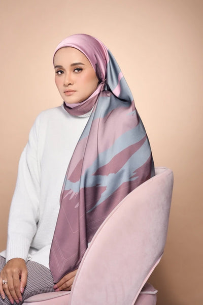 A woman wearing Scarf, a modest and stylish scarf with soft pink and grey patterns, suitable for various occasions and seasons.