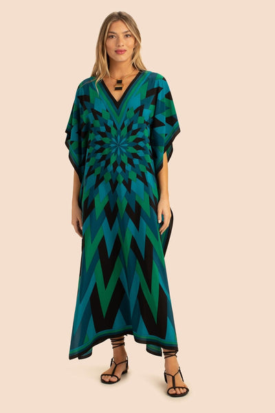 A captivating kaftan with a kaleidoscopic design in shades of emerald and teal green set against a deep black background. The kaftan has a loose, airy fit with a V neckline and drapes elegantly to the ground.